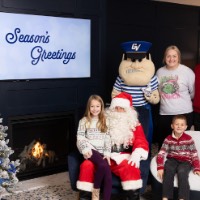 Family with Santa and Louie in Christmas sweaters